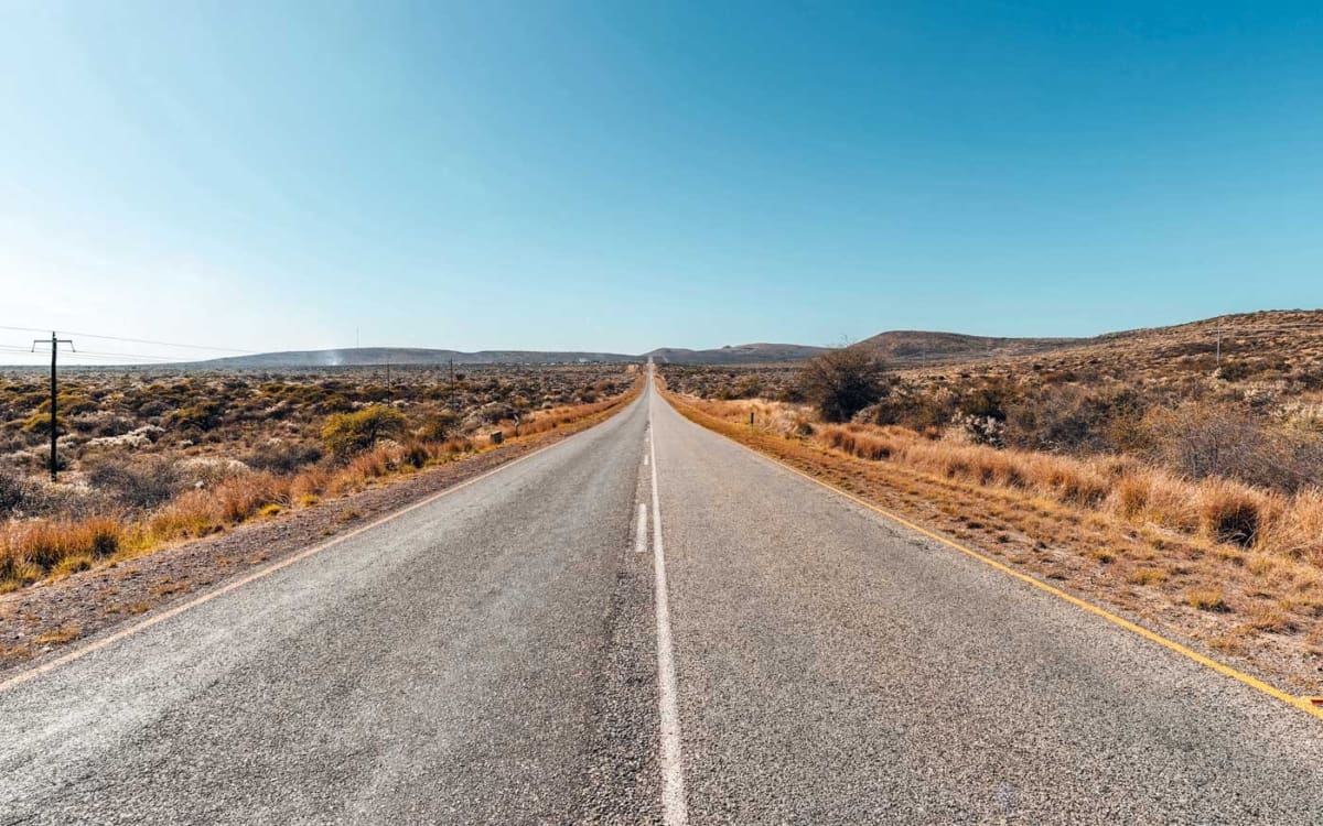 Die endlos geradeaus führende Straße ab Upington zum Nationalpark Eingang Twee Rivieren 